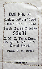 Contractor's label for the khaki trouser to the immediate left.  Kane Manufacturing Co. of Louisville, KY made trousers for the US Army throughout the WW2 period.  Specification PQD 19A involved alternate construction methods that enabled a greater number of manufacturers to produce trousers for the war effort.