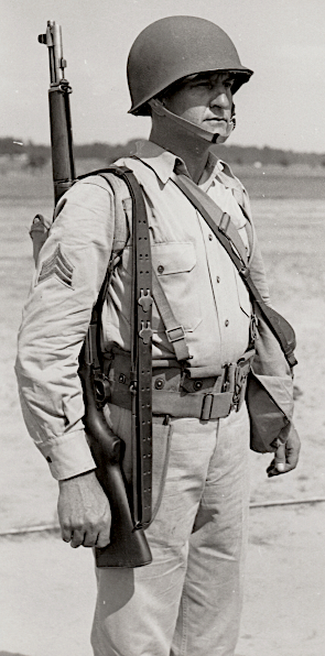 U.S. Army photograph taken at Ft. Benning, Georgia and published 13 August 1941 showing a non‐commissioned officer wearing the hot weather combat uniform.  Note the shirt is worn with an open collar.  When in the field, the necktie was not required.