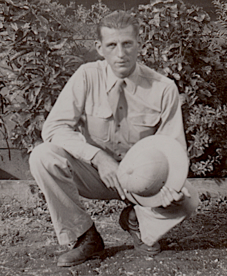 Private John Sabon while stationed in Hawaii in 1942 with his coastal artillery unit.  He wears the khaki cotton uniform with necktie and holds the cloth covered fiber helmet.