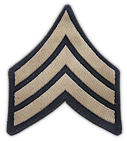 Cotton sergeant chevrons (4th grade).  Washable chevrons designed to be worn with the khaki uniform were introduced in 1936.  The chevrons were khaki colored embroidered  on a dark blue cotton twill background. Chevrons were worn on each sleeve approximately midway between the shoulder and elbow.