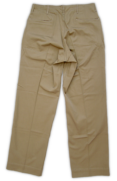 Rear view of the US Army khaki cotton trousers. Note the double welt pocket openings on the seat.  This type of pocket construction would be simplified on later variants of khaki trousers.  Shaping darts can be seen above each rear pocket.  Khaki trousers were an essential part of the enlisted man's individual clothing allowance.  During 1941‐42, most soldiers received two sets of khaki uniforms for their wardrobe.  Khaki uniforms were not taken overseas unless traveling to a tropical climate.