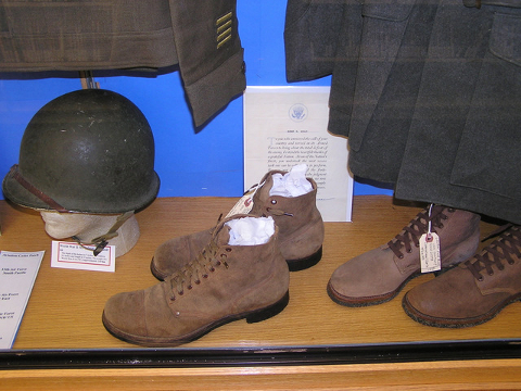 View of Niles Public Library "Service Uniforms of World War II" 2011 Memorial Day display showing U.S. Army russet service shoes, M-1917-A1 helmet, and U.S. Navy high-top service shoes.