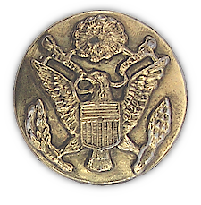 Close‐up view of the enlisted man's gilt service cap ornament worn on the cap shown to the left. The badge was affixed to the front of the cap by way of a threaded post and nut which passed through the cover and riser. Army regulations of 1941 specified that the coat of arms of the United States be a separate piece and be superimposed on a disk 1½‐inches in diameter. World War 2 era cap badges were composed of a variety of materials including brass, gold washed metal alloys, and plastic. Some economy versions were stamped or cast in one piece. The device on the badge featured here shows a distinct lack of detail indicating it is cast in one piece.