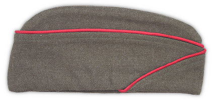 Right side view of the restyled olive‐drab field cap of 1940 (Caps, Field; Specification dated 11 October 1940). This cap featured rounded peaks, a bellows crown, and a turned‐up curtain that crossed in the front. It replaced the previous cap which had pointed peaks. The fabric was an 18‐ounce serge wool in olive drab shade 33. This cap was used for both field and garrison wear and began replacing the campaign hat and service cap as a general issue item in the fall of 1940. By mid‐1942, components of the wool service uniform were reclassified as garrison clothing resulting in the nomenclature for the field cap being changed to the more familiar garrison cap.